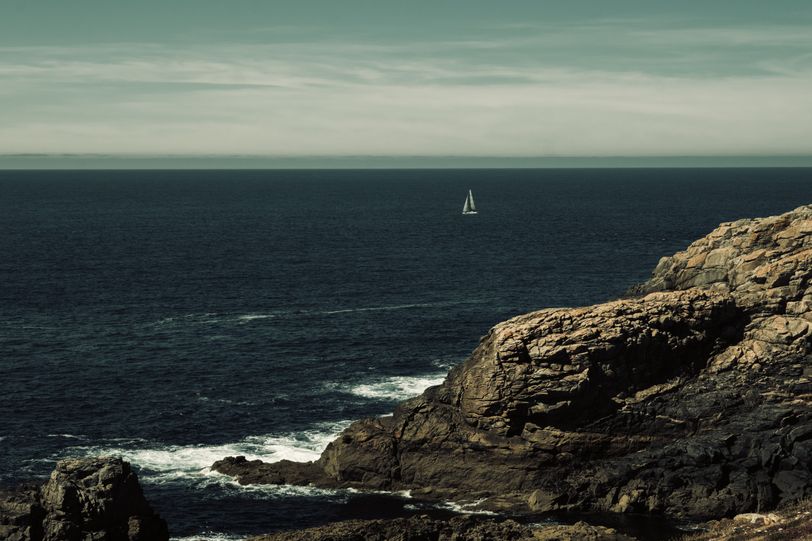 A sailboat at sea from the shore