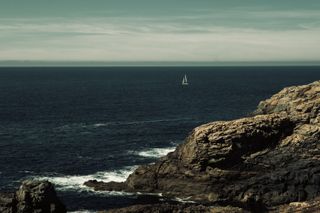 A sailboat at sea from the shore