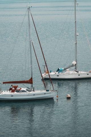 Two sailboats next to each other at sea