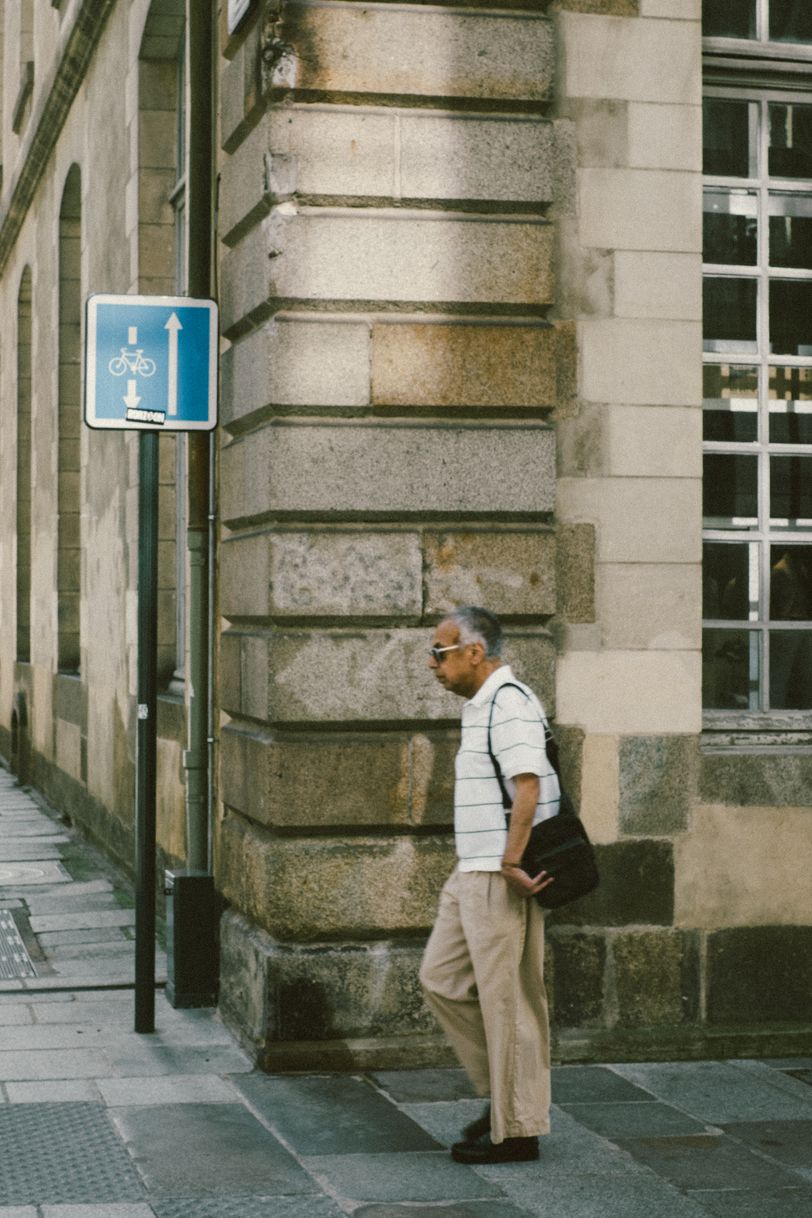 A man walking and approaching the corner of a street
