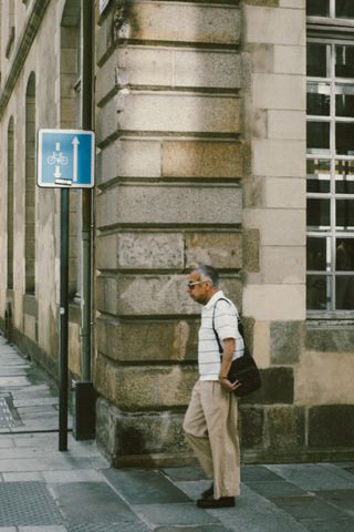 A man walking and approaching the corner of a street