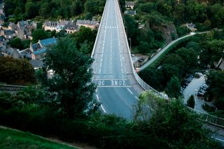 An empty road on a massive bridge going over a rural valley