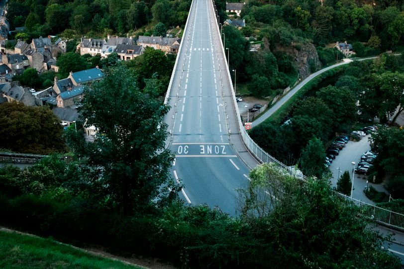 An empty road on a massive bridge going over a rural valley