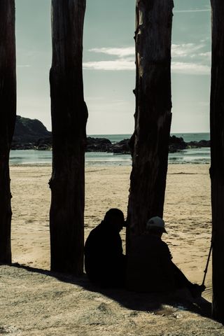 A couple resting near breakwater poles