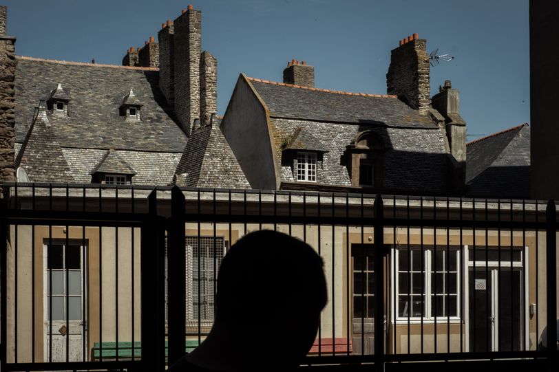 An enlighted house behind a fence in the dark