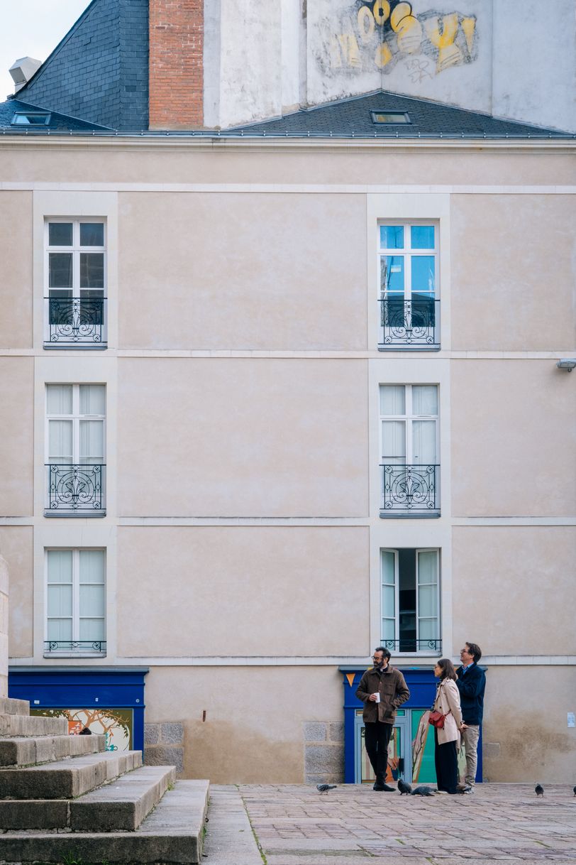 People chatting in the street in front of a clean building