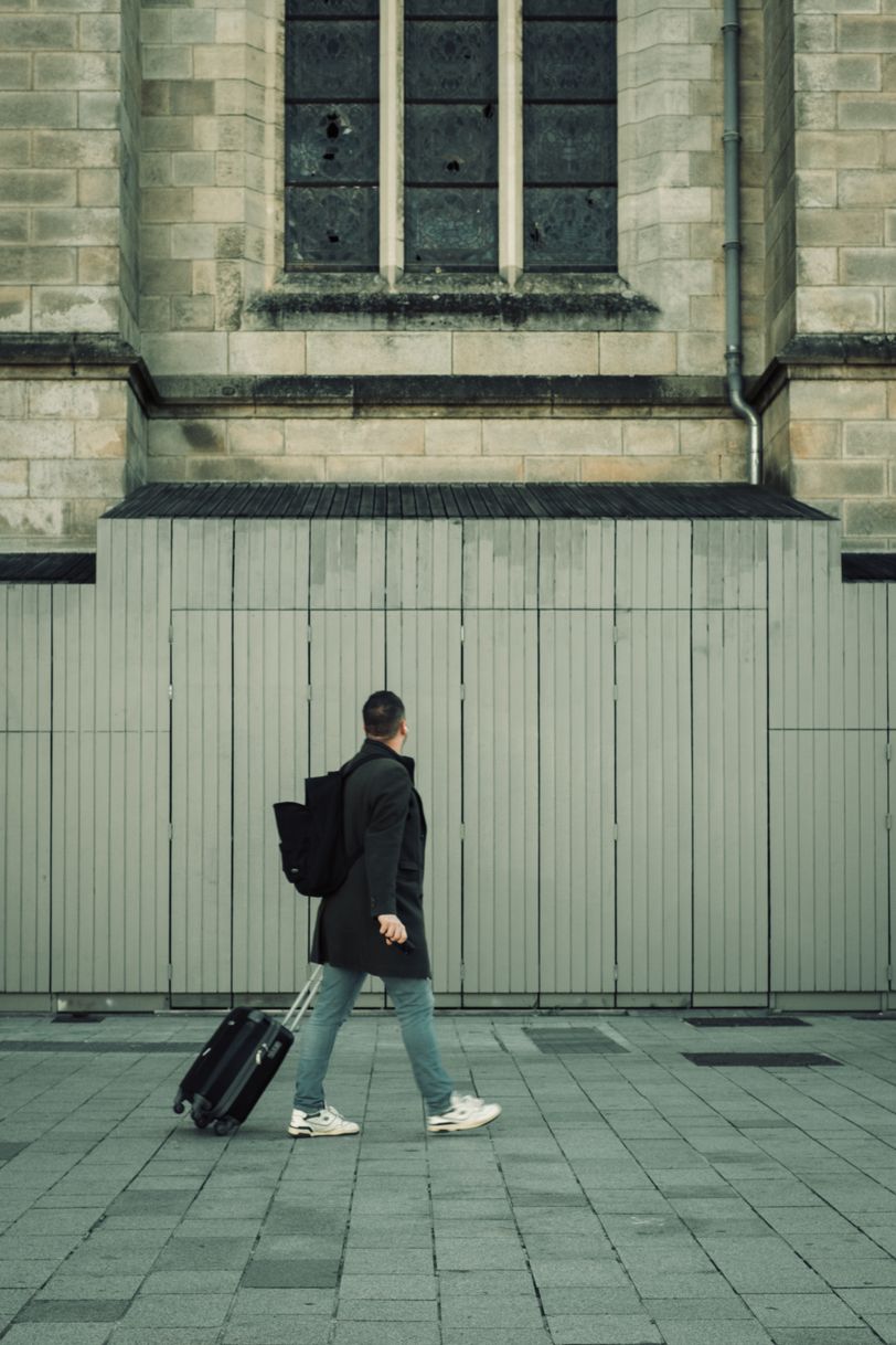 A traveller passing by a church under restoration with broken stained glass
