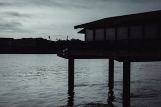 House on stilts on a river at dusk