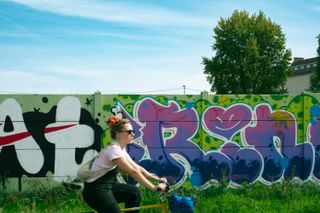A cyclist passing by a wall colorfully painted
