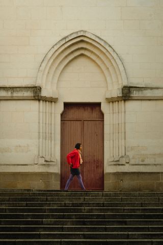 A colorful lady passing by the church's door