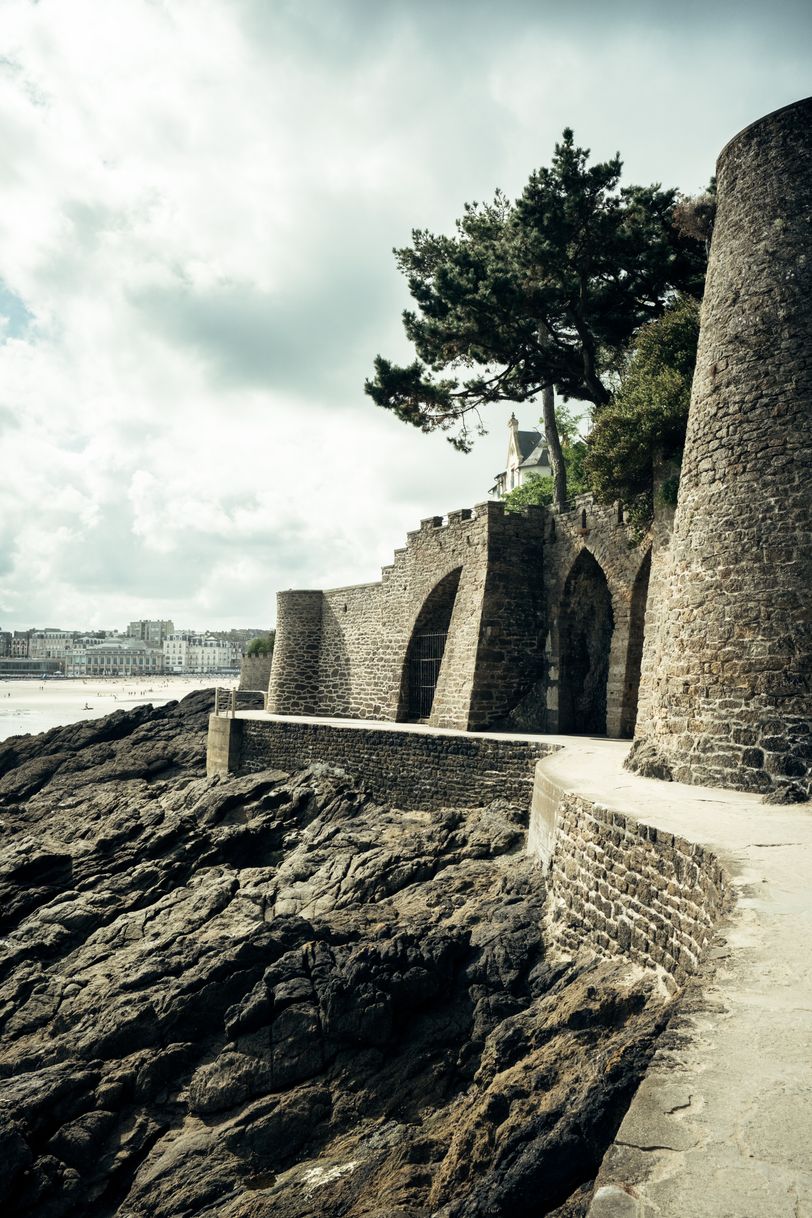Coast with fortifications and a city in the background