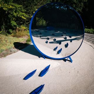 Little blue boats reflecting in a mirror of a well decorated garden