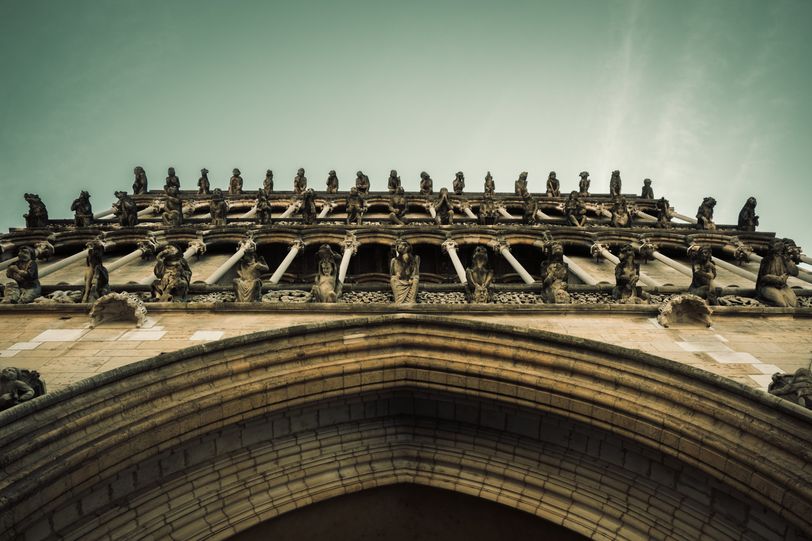 Facade of a church filled with gargoyles viewed from below