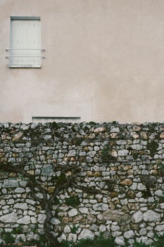 Facade of a house behind a stone wall