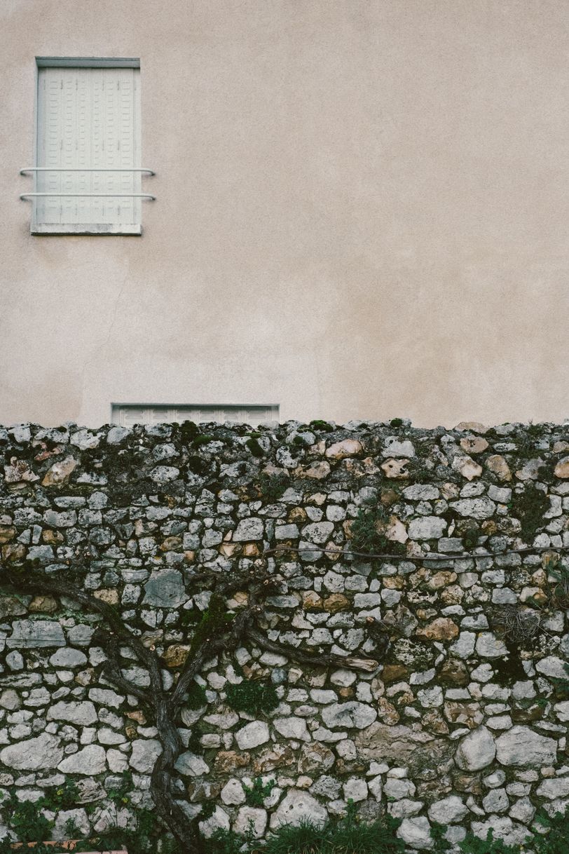 Facade of a house behind a stone wall