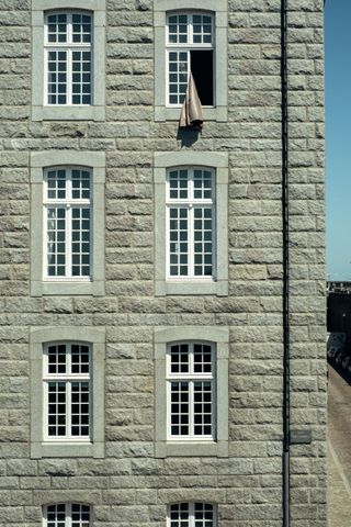 Facade of a building with all windows looking the same but one