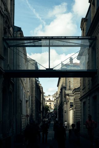 Glass corridor passing above a pedestrian street in the city