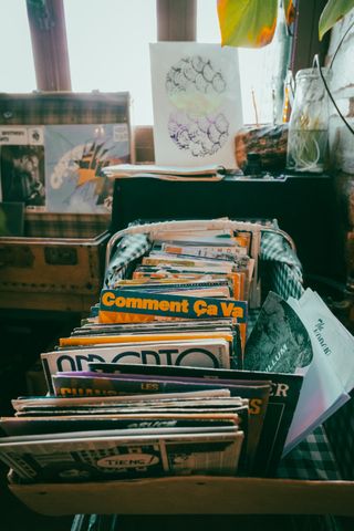 A box full of vinyls with one particularily standing out with the writing "Comment ça va" which means how are you doing in french