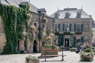 View to the center place of an old town with flowery buildings and an old flowery well