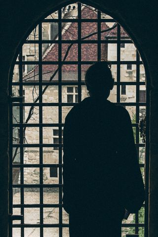 Backlight of a woman looking through a window