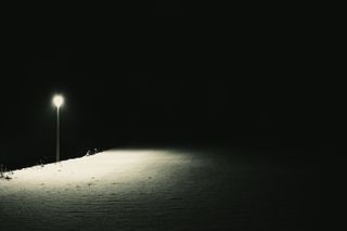 Street lamp in a dark snowy night