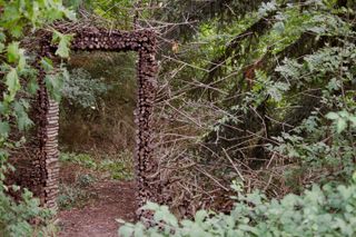 Frame of a door made of wood sticks in a forest