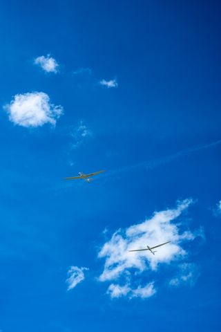 A plane pulling a glider in a blue sky