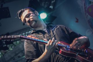 Close up of Black Strobe singier playing the guitar on stage