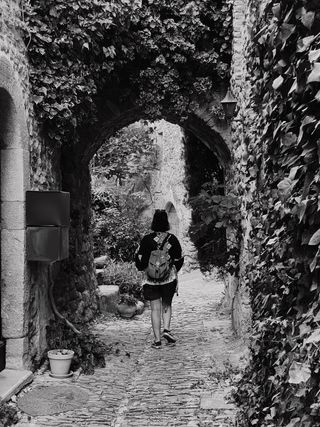 A woman going through an arch in a medieval street