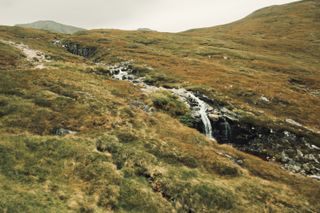 Top of a hill with a water source running its way down