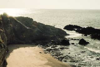 A cove on a beach with stairs carved in the rock