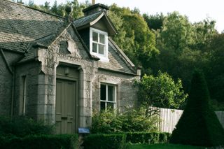 A cozy little scottish cottage made of stone with a sunset light