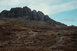 A man walking a path leading high in the mountain