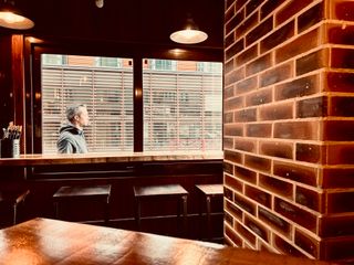 View of a street from a café with lines everywhere and someone outside passing by the window