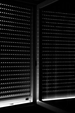 Black and white picture of window blinds from inside a room