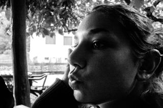 Black and white close up portrait of a woman making a smooching face