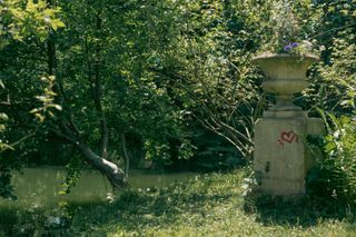 A stone flower pot tagged with a red heart