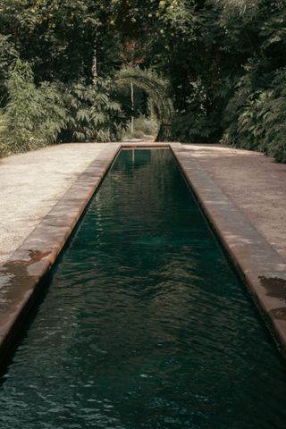 A long man built pond before a wooden tunnel