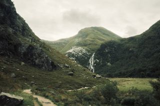 Landscape of a valley with the Steall falls waterfall in the back