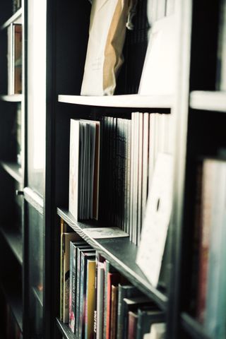 Bookcase from the side enlighten by outdoor light, with a open book stored in it