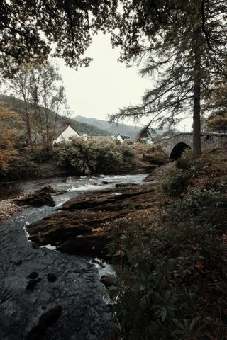 View on a river going under a bridge with houses in a valley on the other side