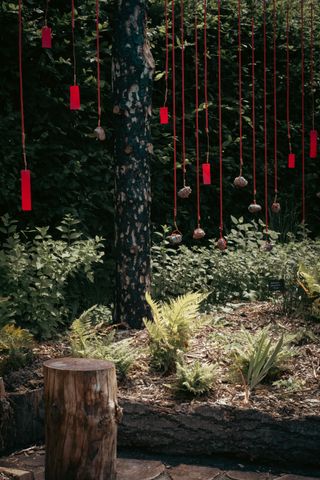 Red strings as branches coming from a burned tree and a log put in front of it to sit on