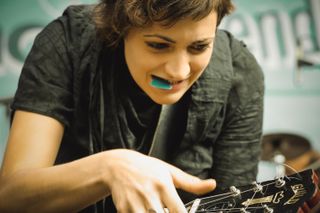 Mell changing a cord on her guitar on stage