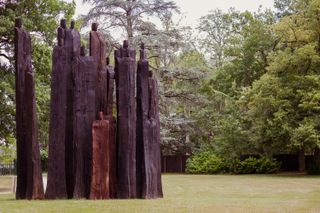 Wooden sculptures of people in a wooden area