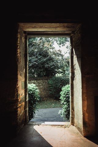 Stone frame door leading to a garden outside