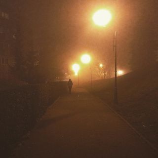 Barely lit path on a very foggy night