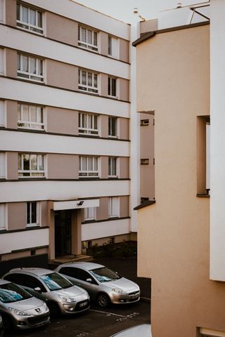 Building complex with three grey cars parked next to each other