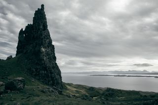 A massive erect rock on a hill watching over the lake below