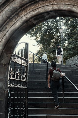 Framed view of the entering stairway to a cemetery with people going up and down