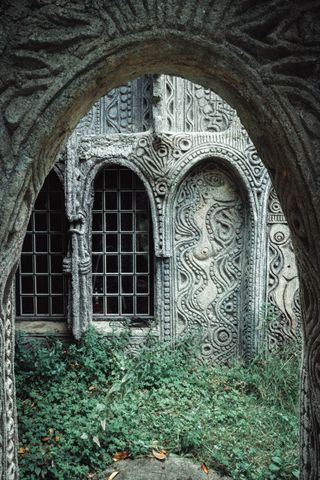 Picture of a handmade porch with sculptures on the wall where we can see drawn naked ladies